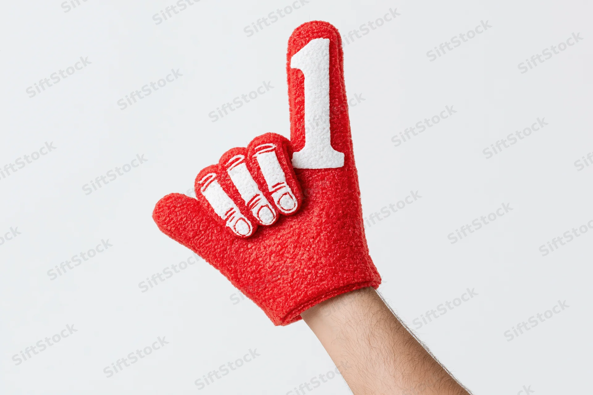 Hand wearing red foam finger with number one raised against white background