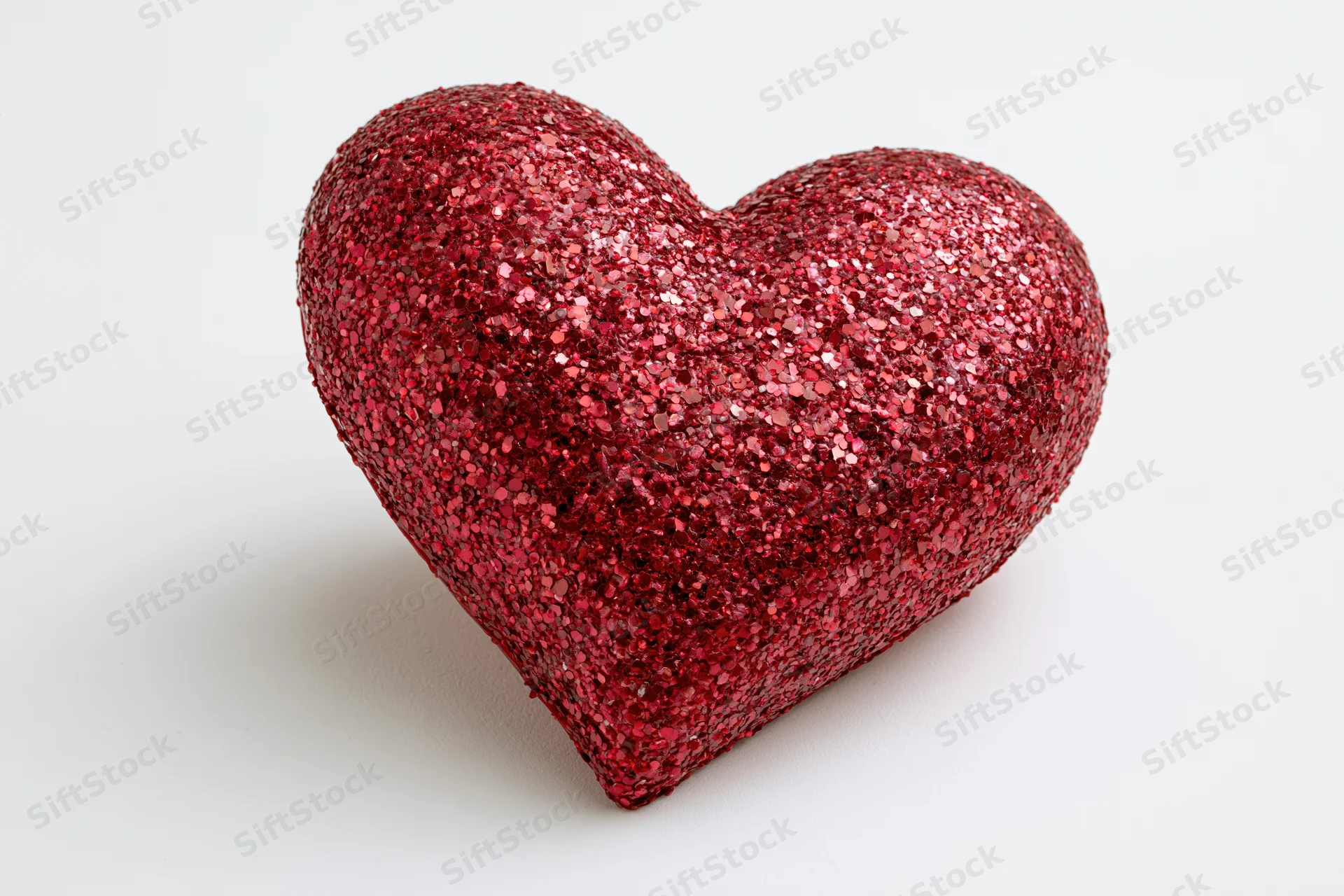 Red glitter heart decoration on white background
