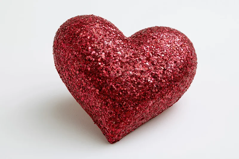 Red glitter heart decoration on white background