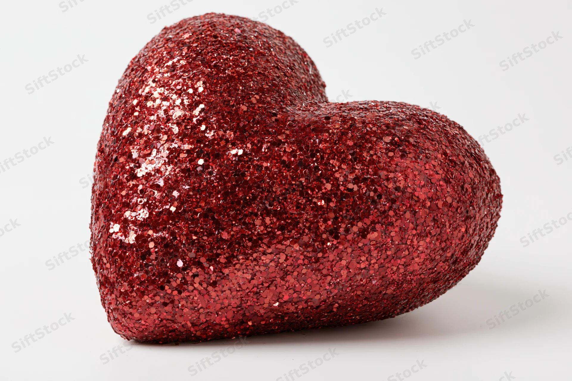 Red glitter heart decoration on white background