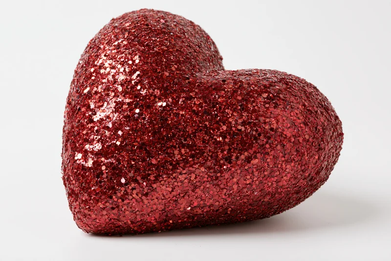 Red glitter heart decoration on white background