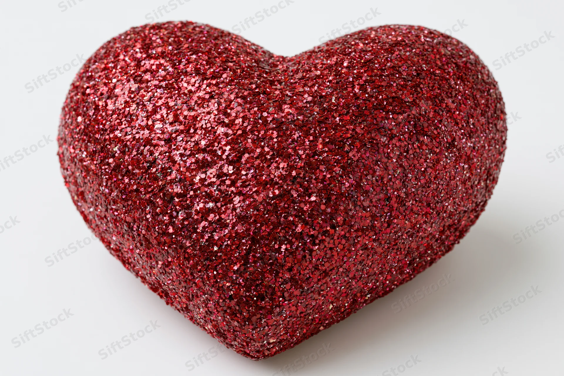 Red glitter heart decoration on white background