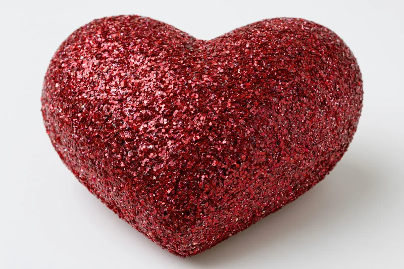Red glitter heart decoration on white background