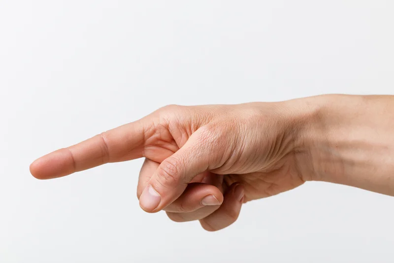 Hand with index finger extended pointing sideways against white background