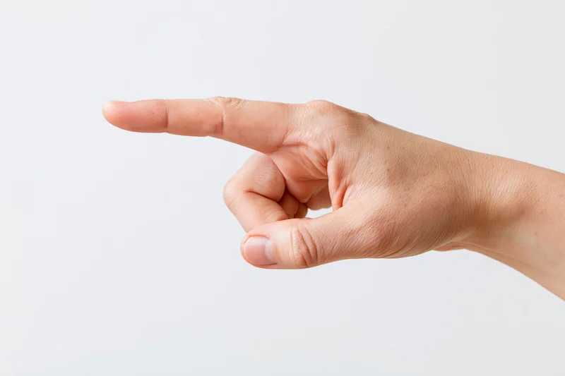 Hand with index finger extended pointing sideways against white background