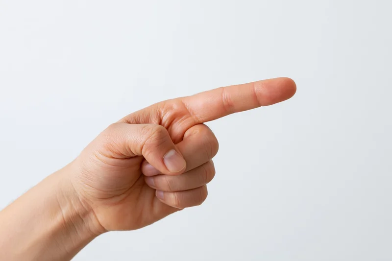 Hand with index finger extended pointing sideways against white background