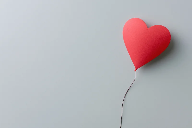 Red paper heart cutout on gray background with copyspace