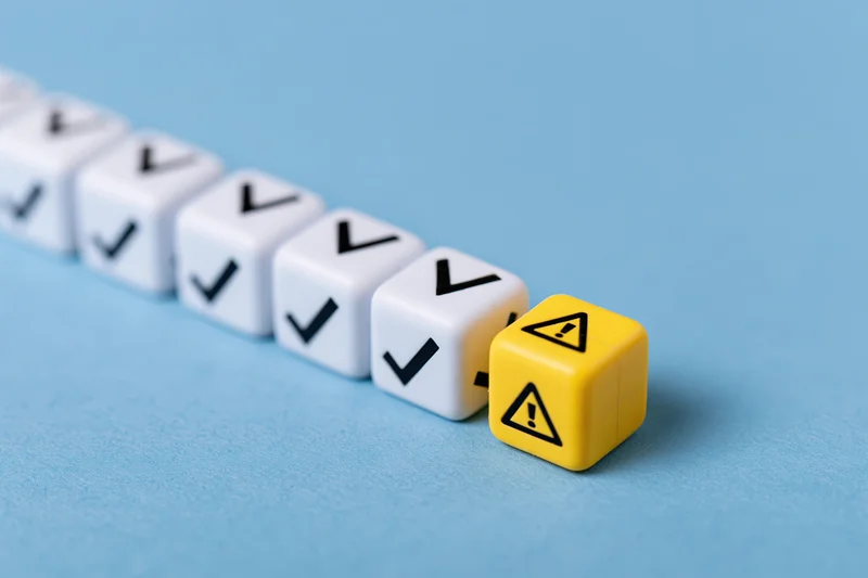 Row of white dice with checkmarks ending in a yellow warning die on blue surface