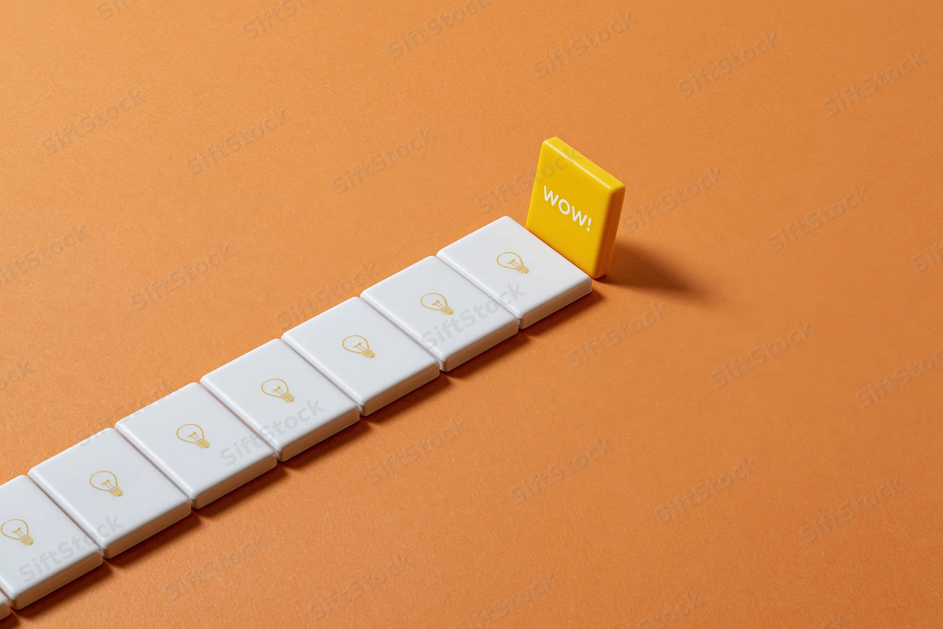 Row of white tiles with lightbulb icons leading to a yellow tile with wow text on orange surface