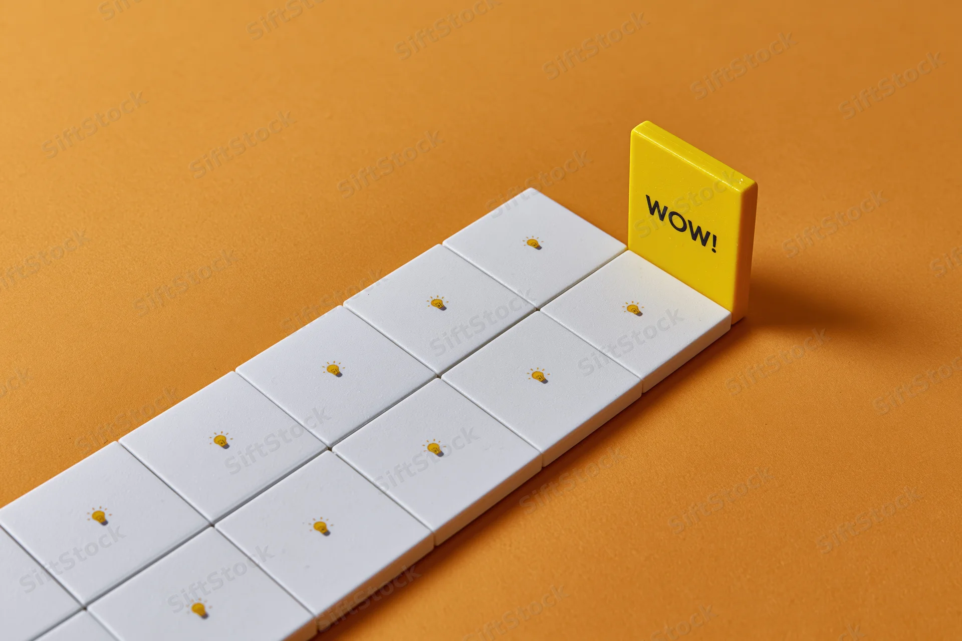 Row of white tiles with lightbulb icons leading to a yellow tile with wow text on orange background
