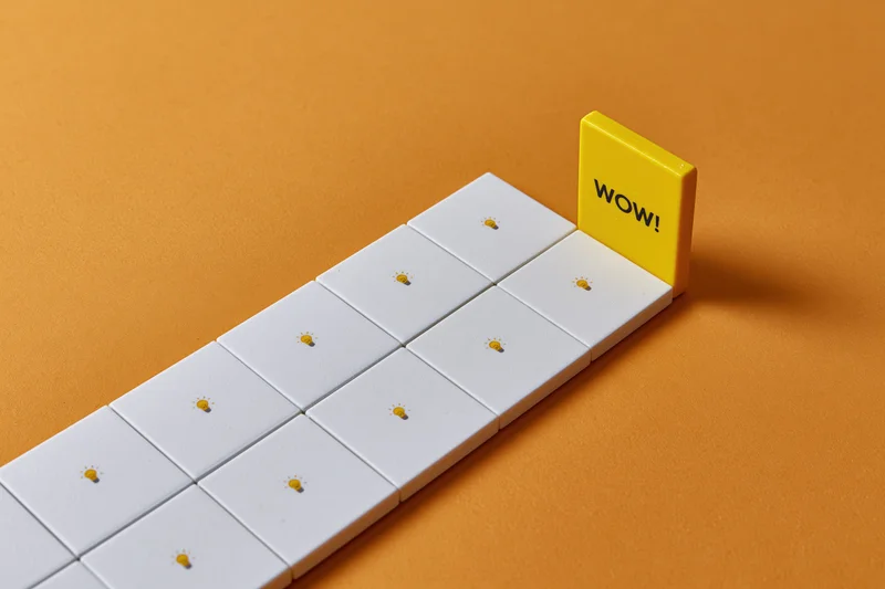 Row of white tiles with lightbulb icons leading to a yellow tile with wow text on orange background