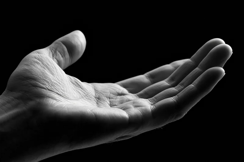 Open hand cupped upward against black background