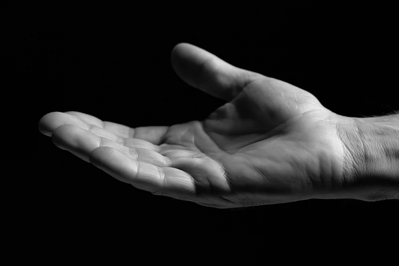Open hand cupped upward against black background