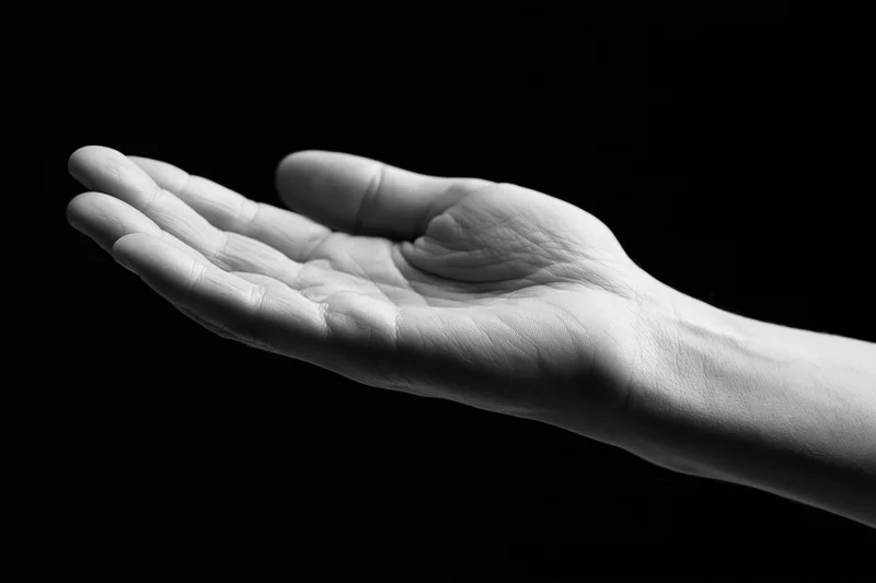 Open hand cupped upward against black background