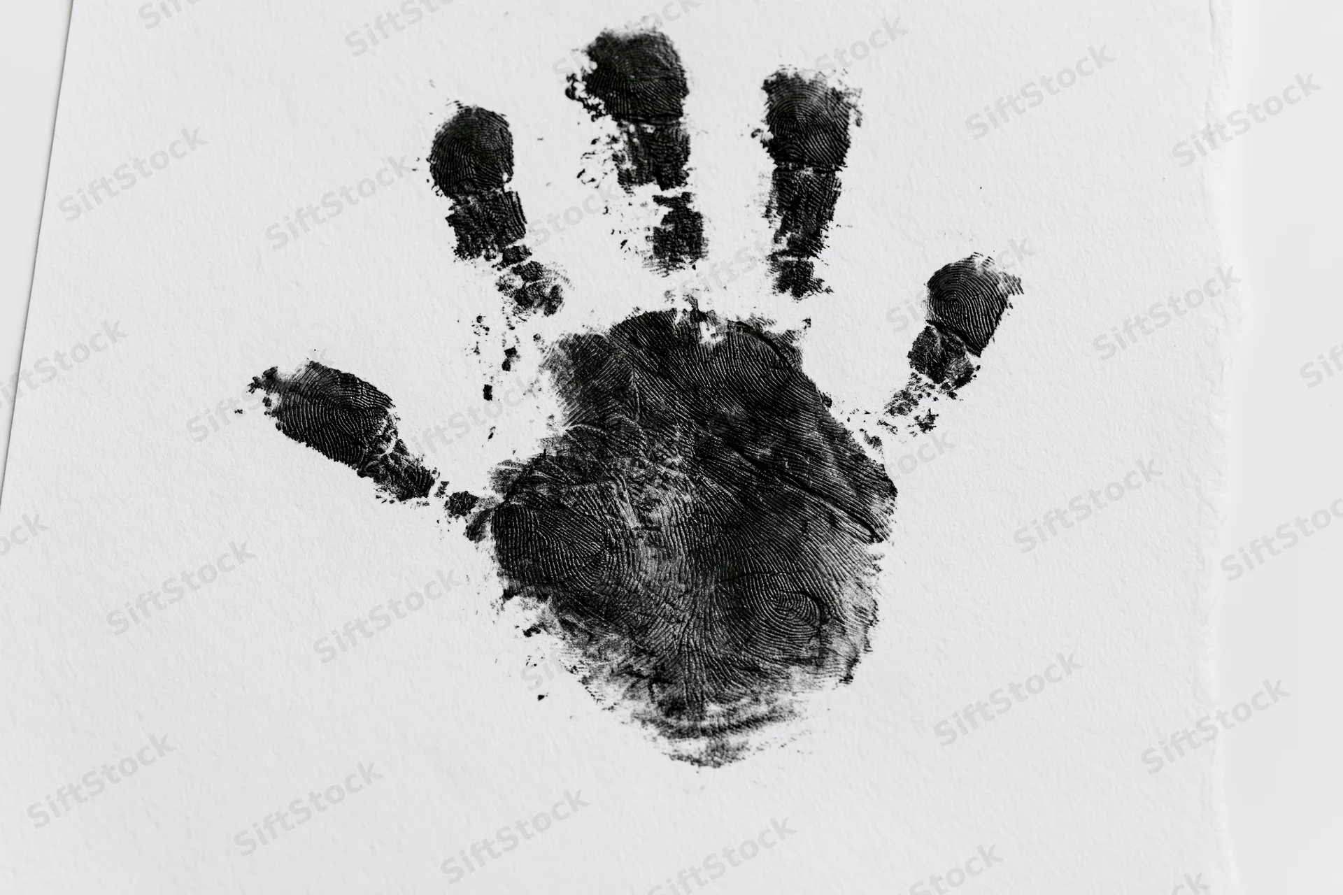 Black ink handprint of a child's hand on white paper