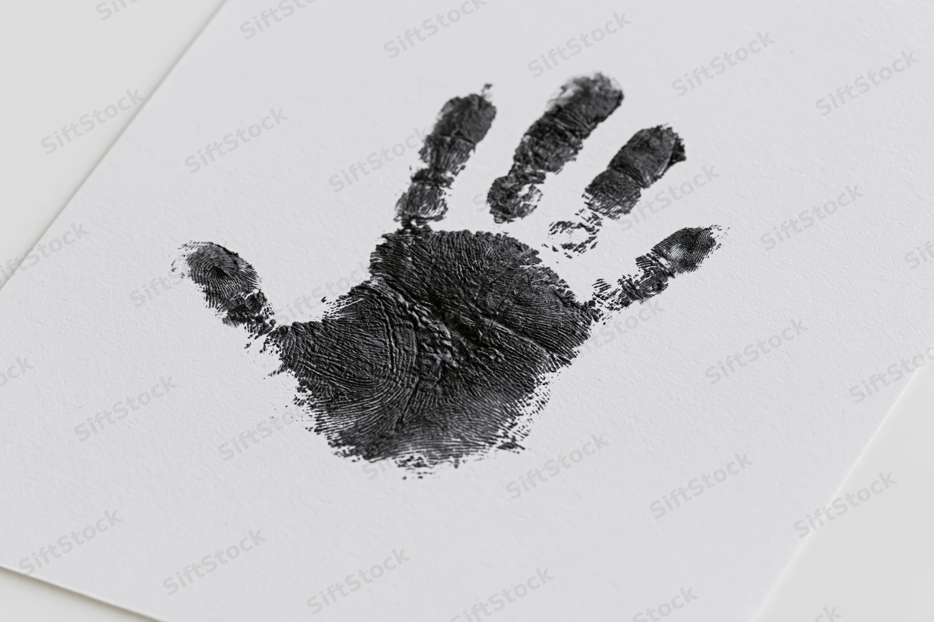 Black ink handprint of a child's hand on white paper