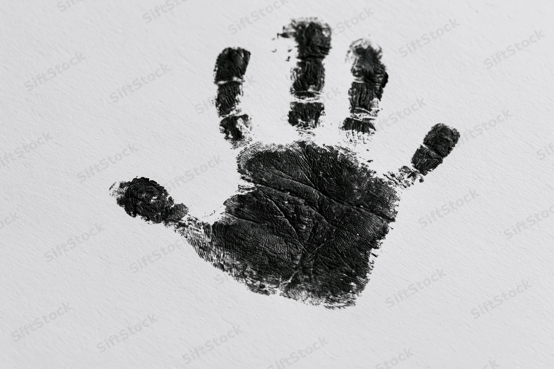 Black ink handprint of a child's hand on white paper