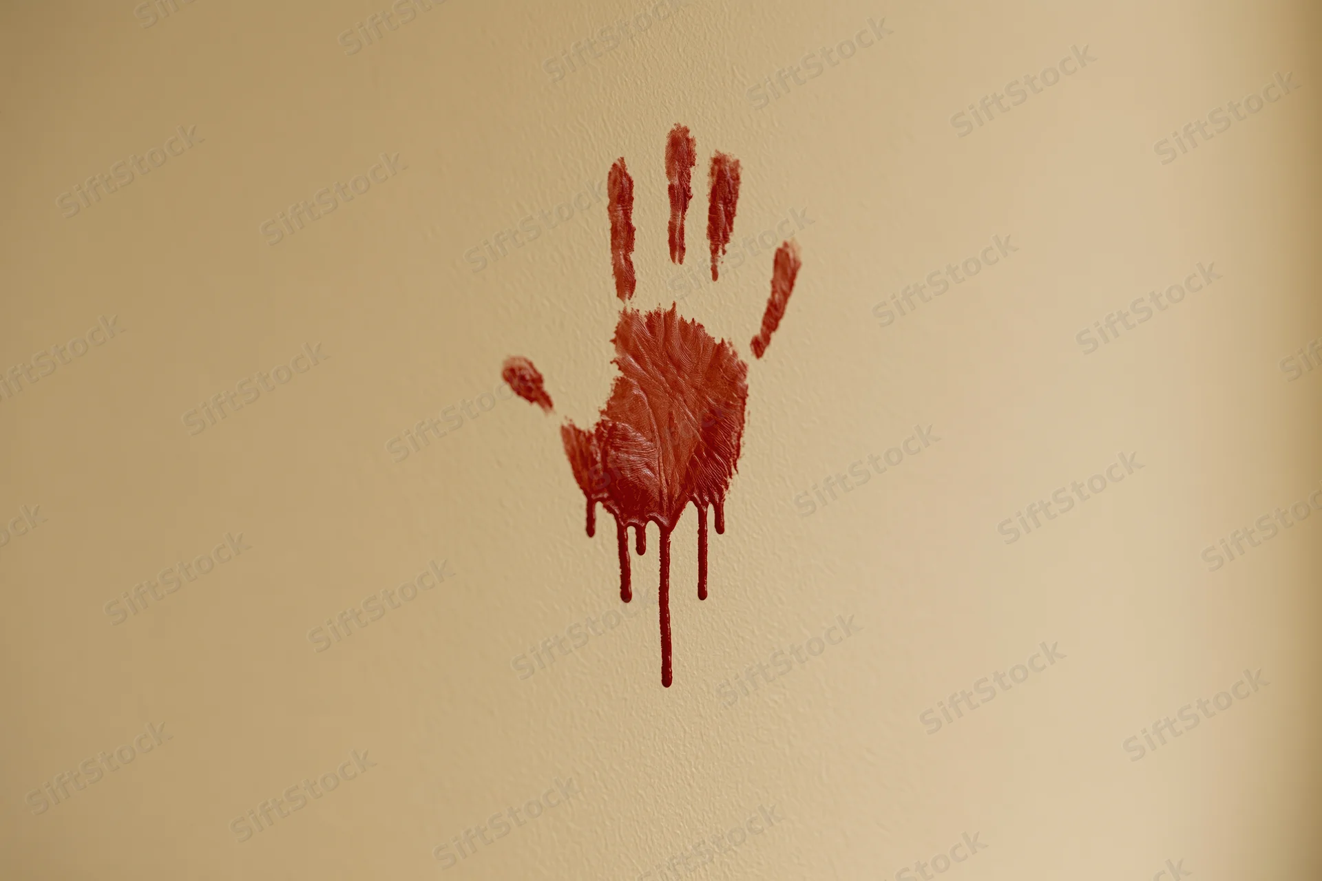 Bloody handprint smeared on beige wall with dripping paint
