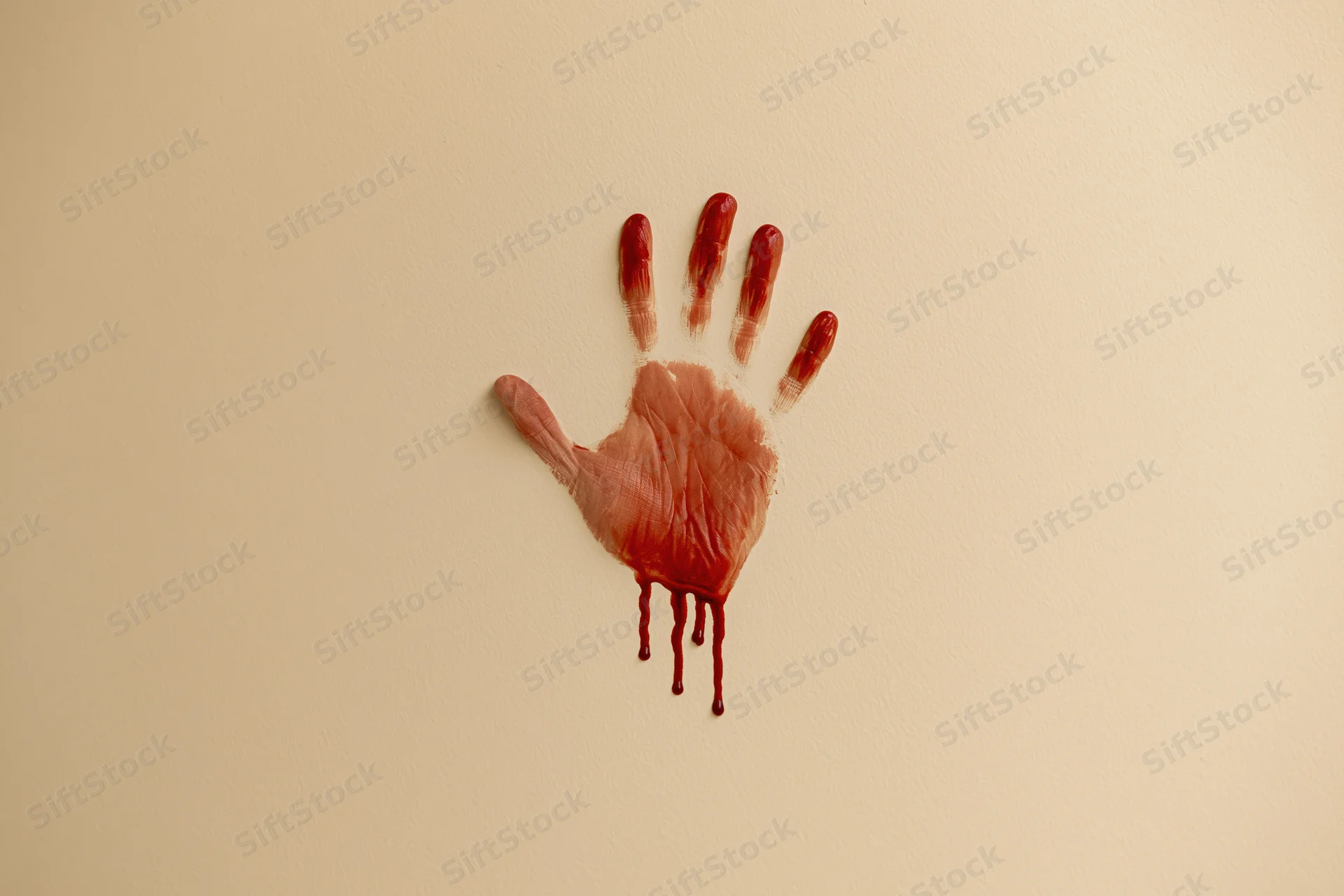 Bloody handprint smeared on beige wall with dripping red stain