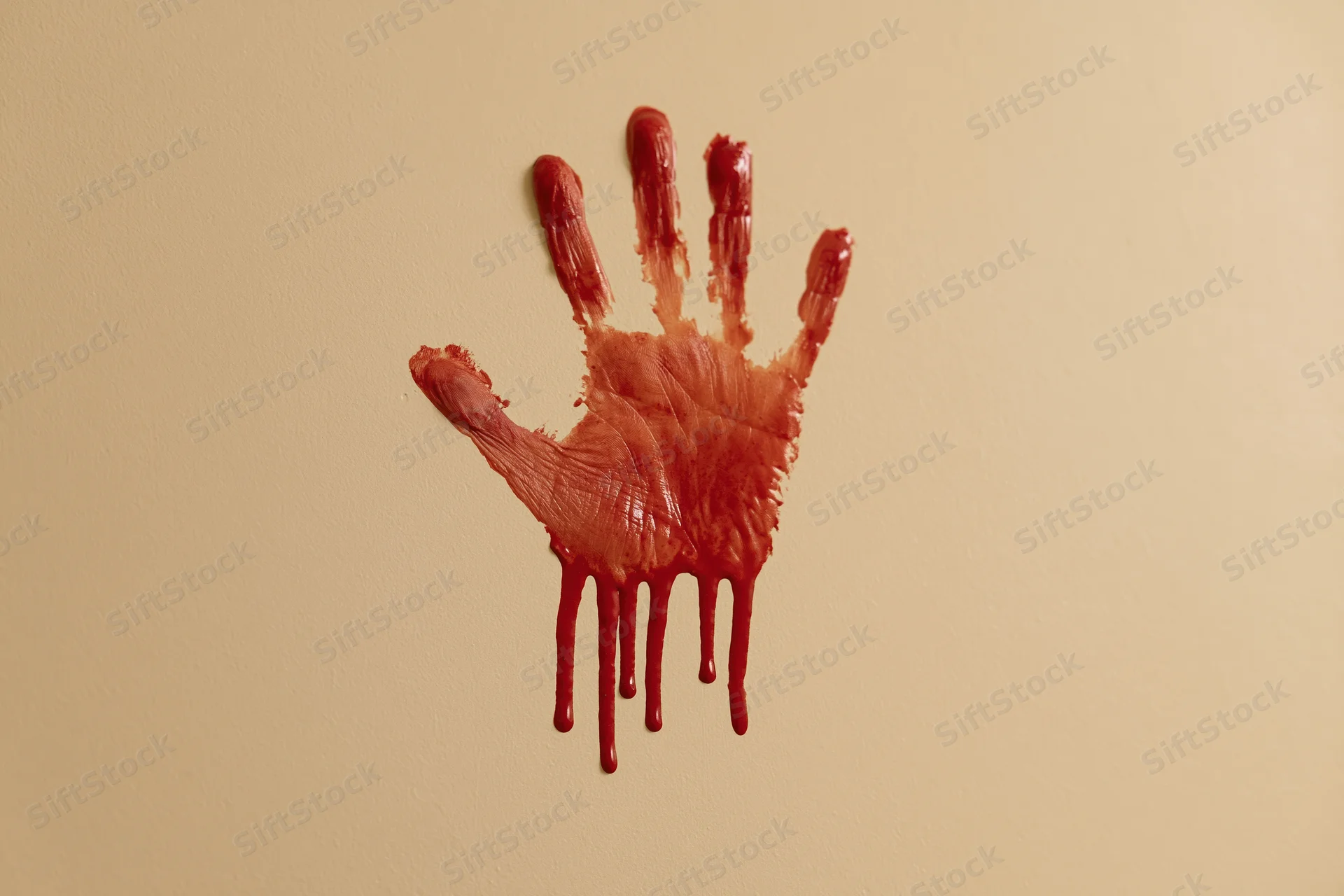 Bloody handprint smeared on beige wall with dripping red paint