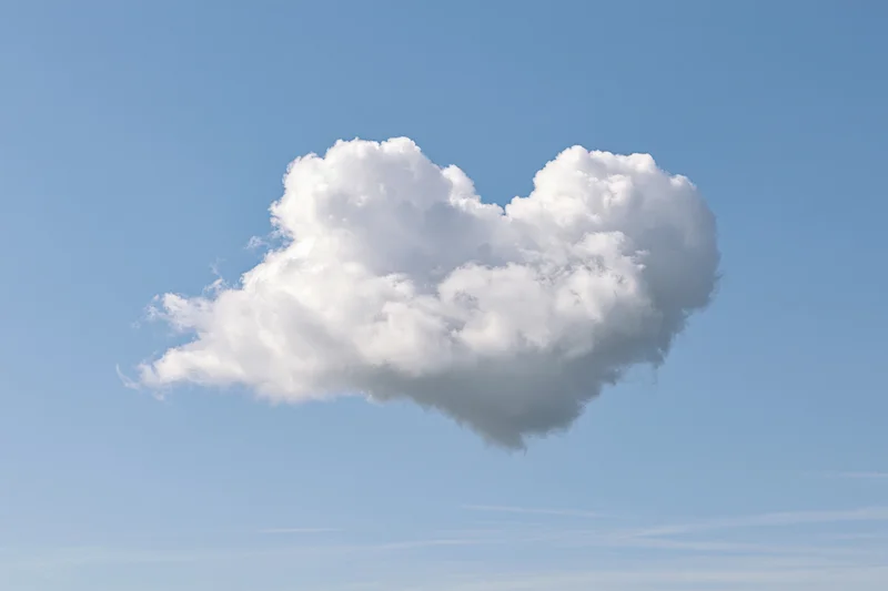 Heart-shaped cloud floating in clear blue sky