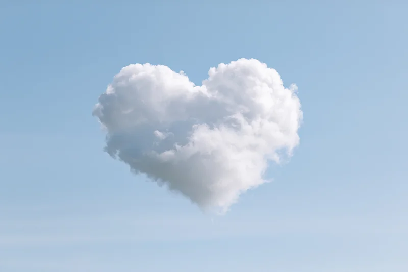 Heart-shaped cloud floating in clear blue sky