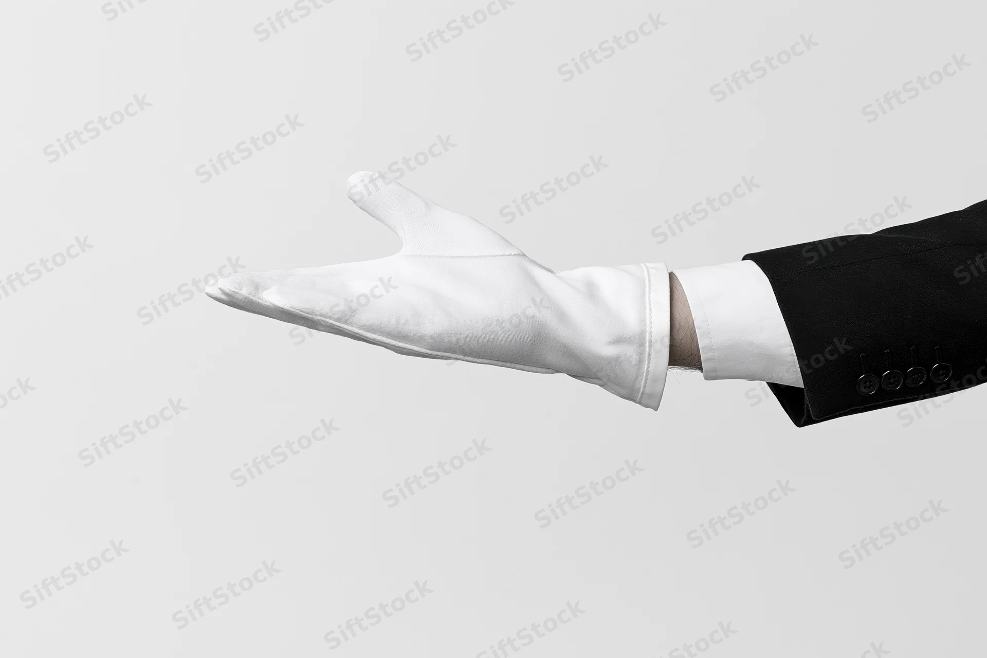 Gloved hand extended palm up in formal suit sleeve against white background