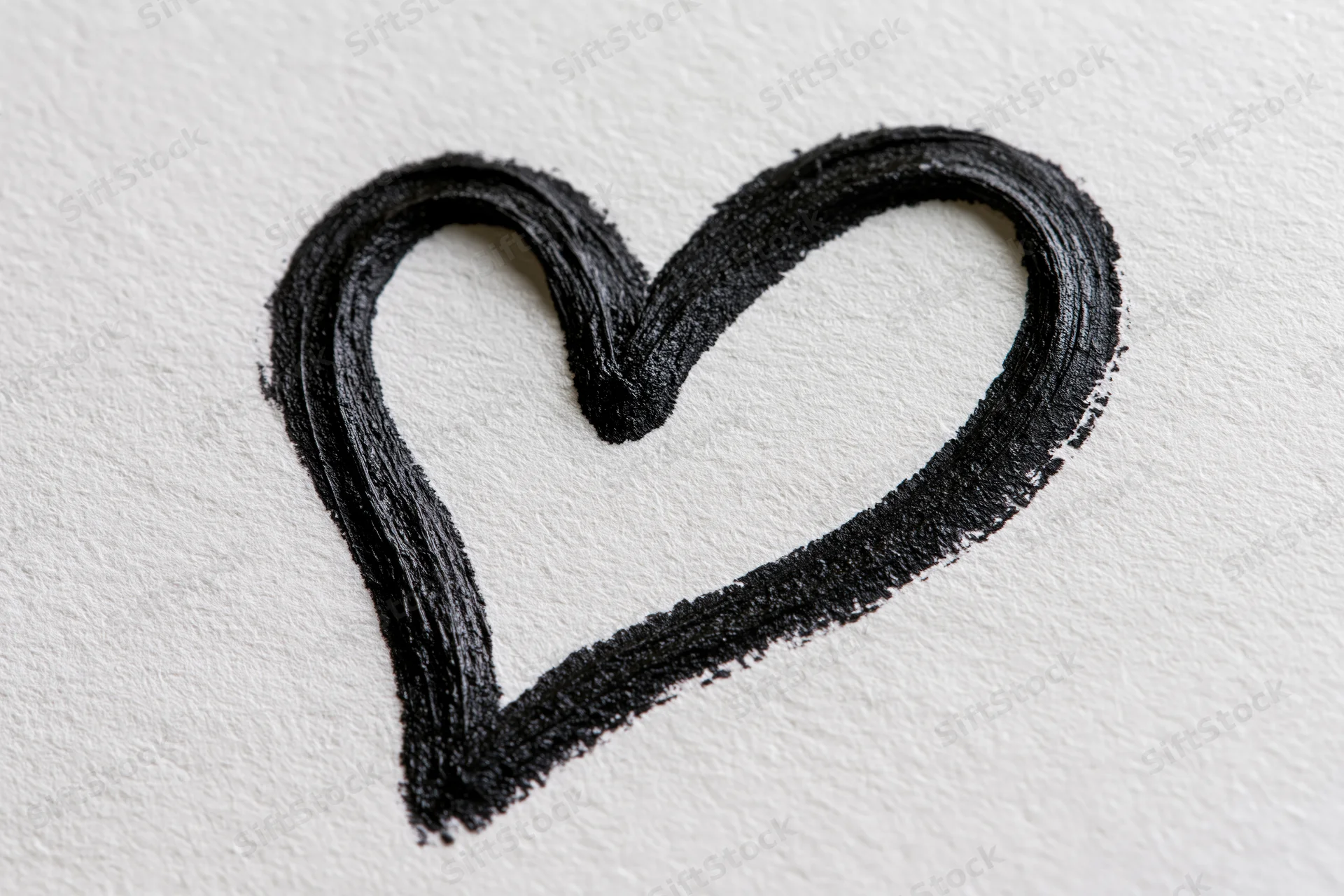 Hand-drawn black heart outline on white textured paper