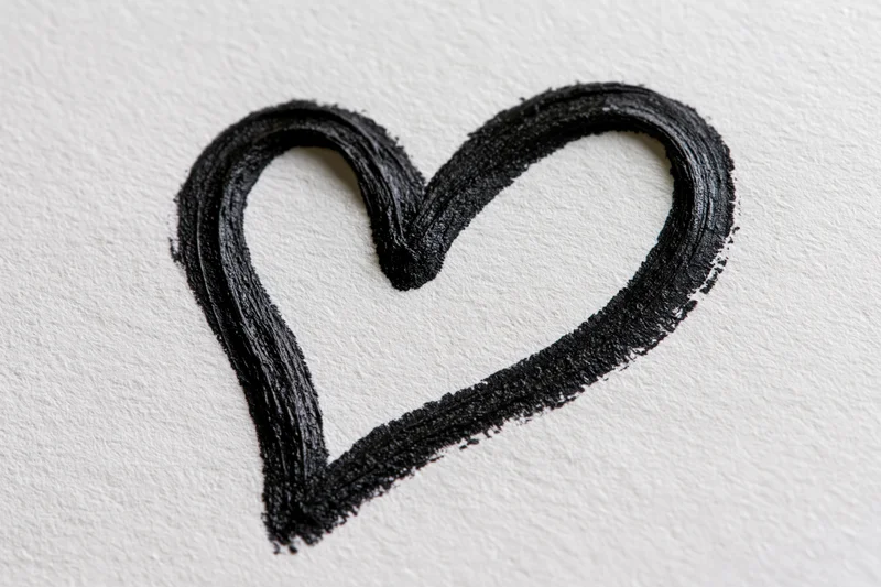 Hand-drawn black heart outline on white textured paper