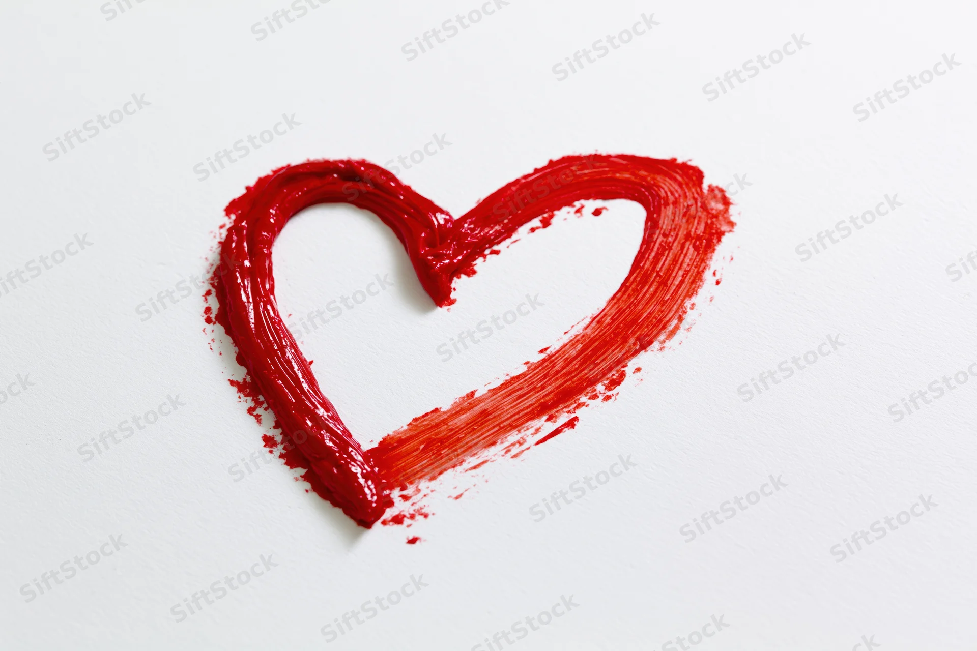 Hand-drawn red heart outline painted with thick brushstrokes on white background