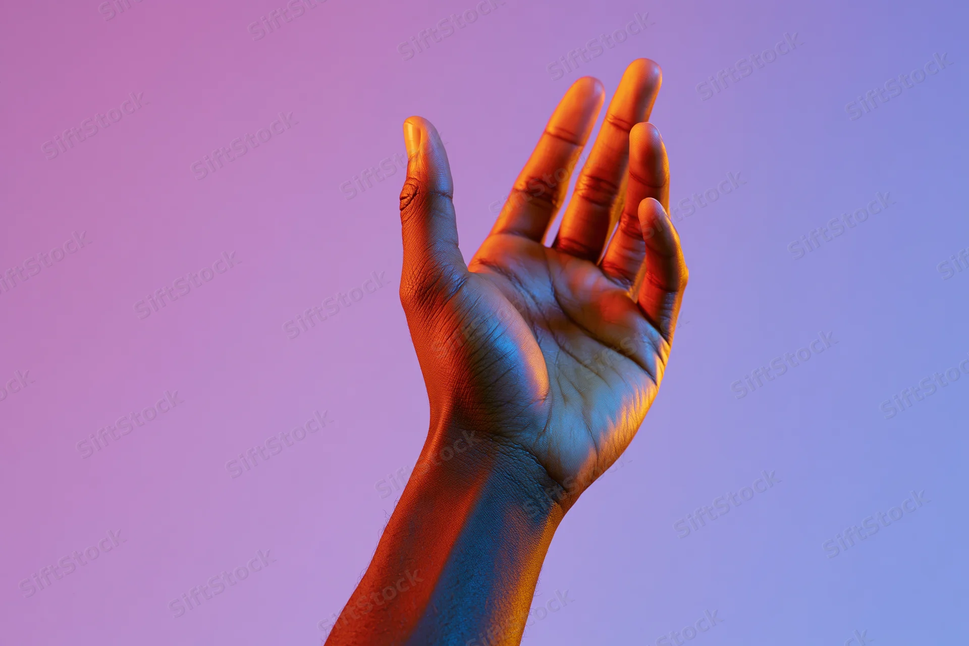 Hand reaching upward with fingers slightly spread against a gradient neon background