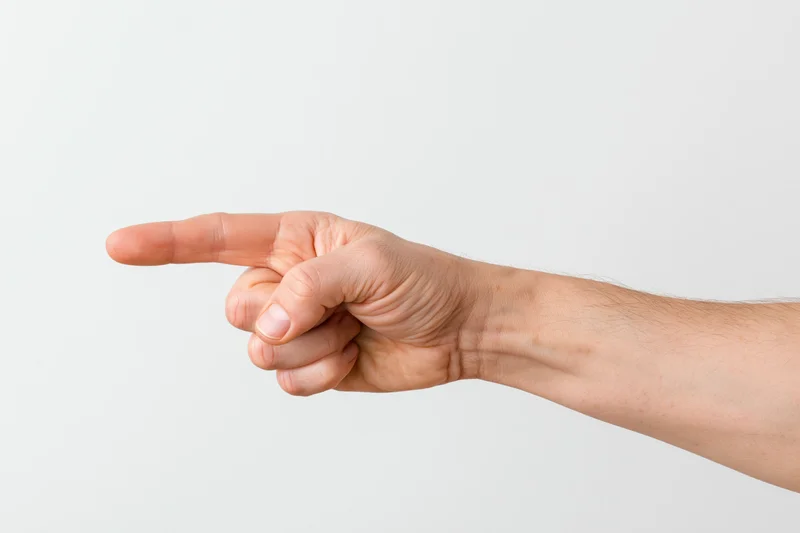 Hand pointing with index finger extended against white background