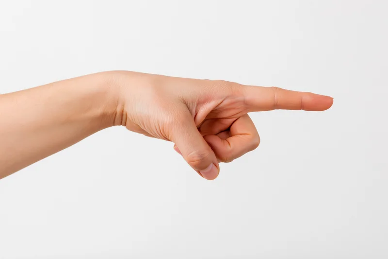 Hand with index finger extended pointing sideways against white background