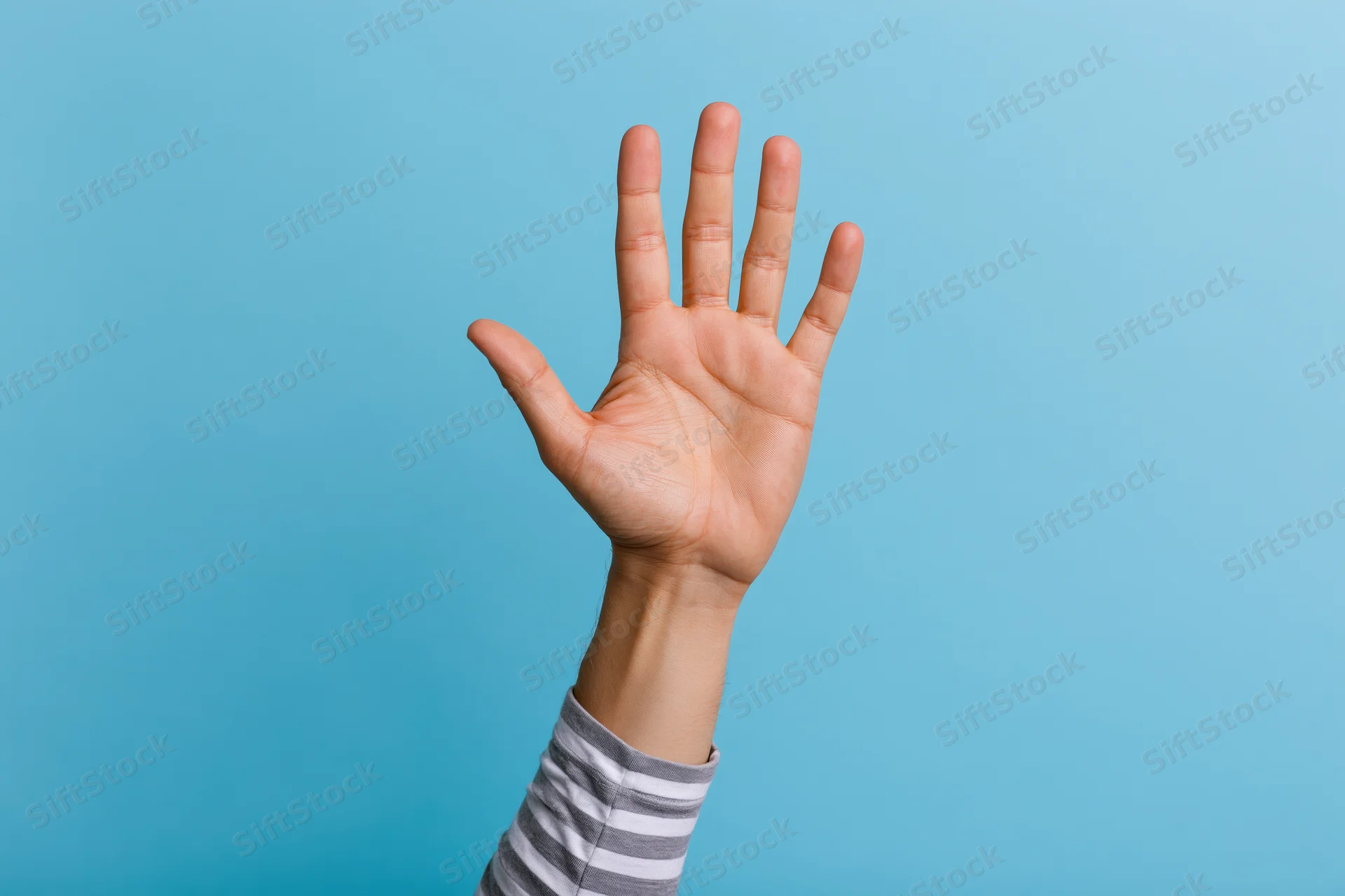 Raised hand with open palm and all five fingers extended against blue background