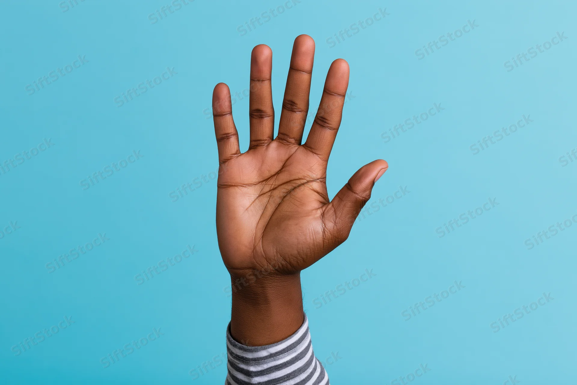 Raised hand with open palm and all five fingers extended against a blue background