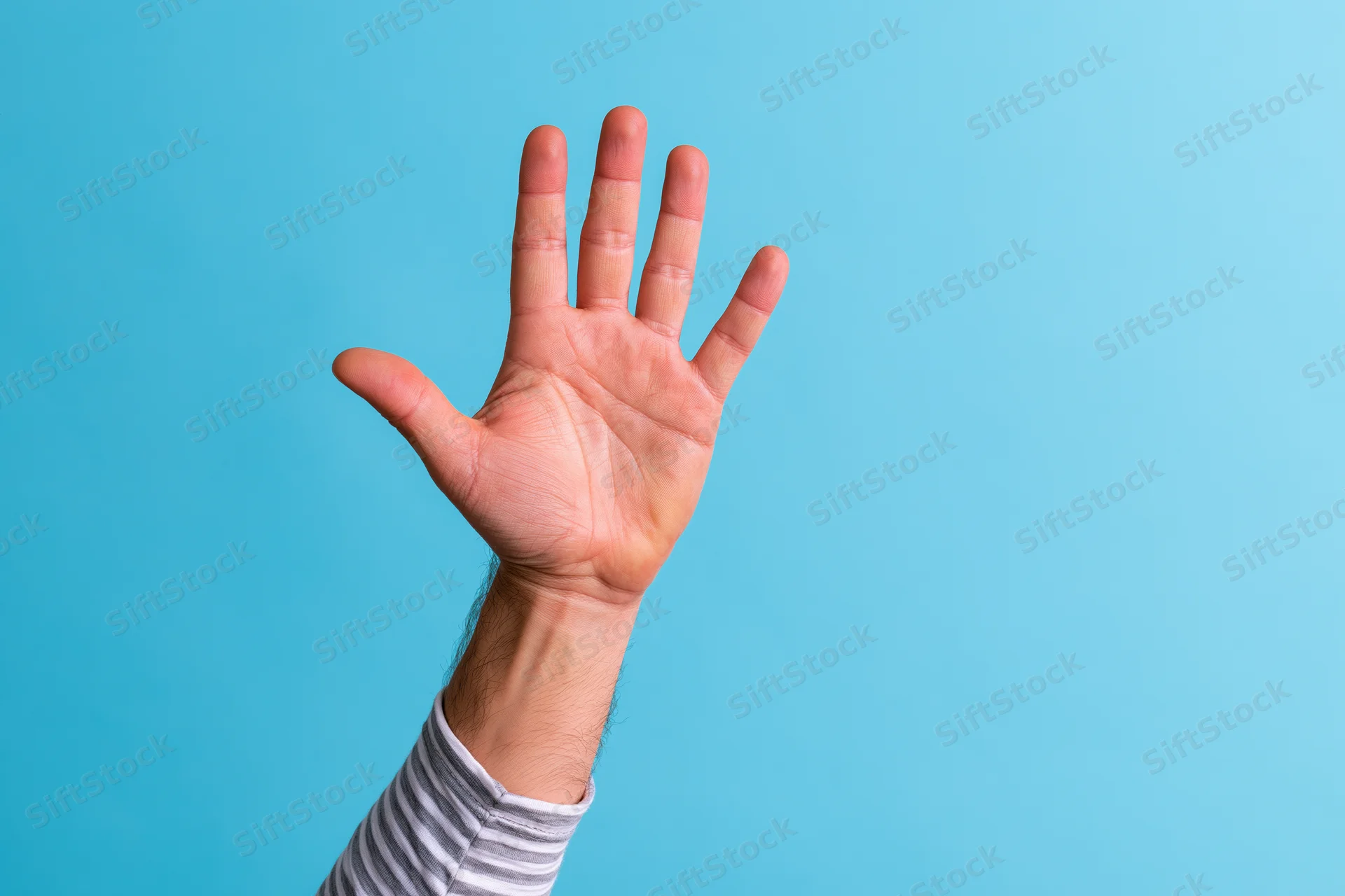 Raised hand with open palm and all five fingers spread against blue background