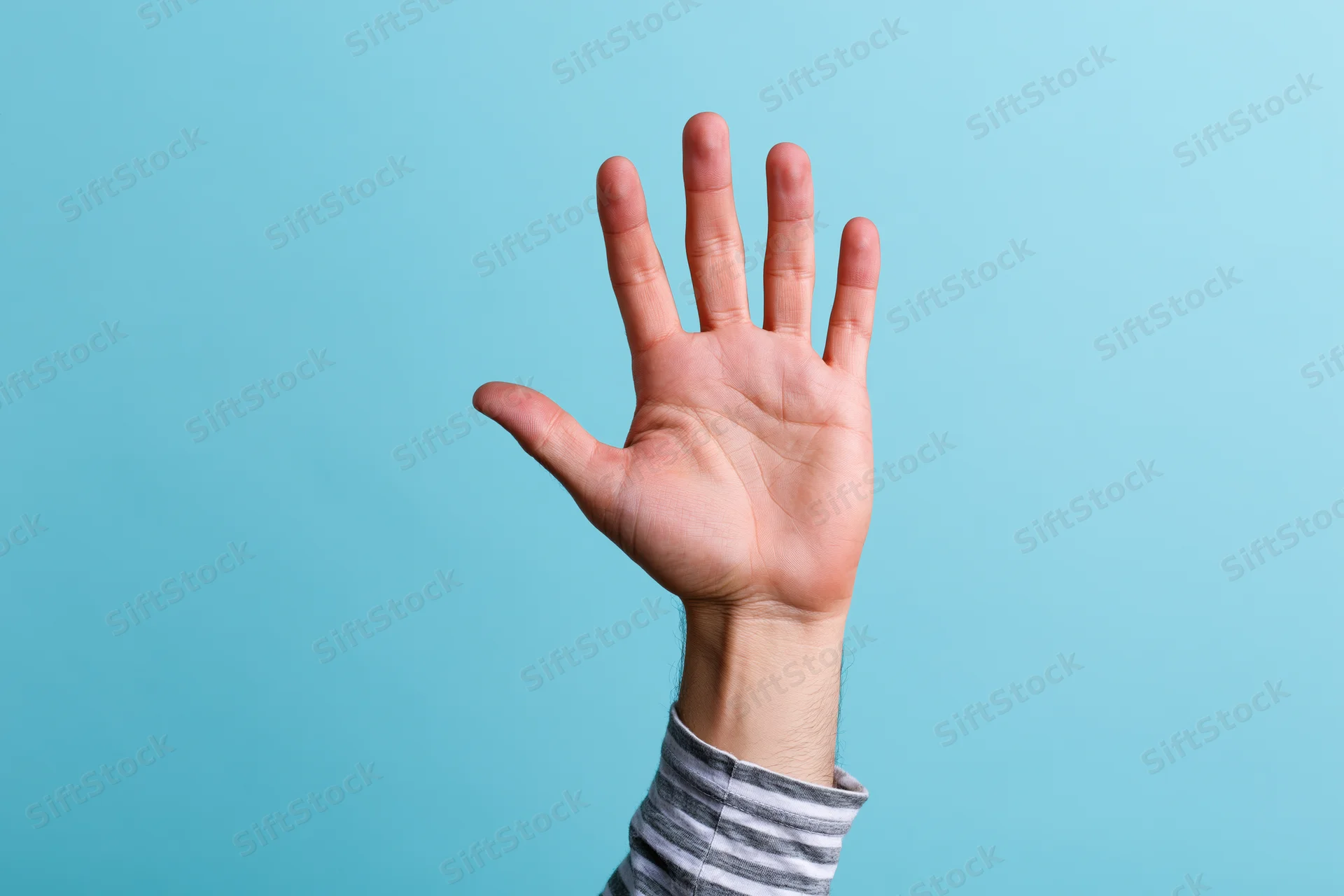Raised hand with open palm and all five fingers extended against a blue background