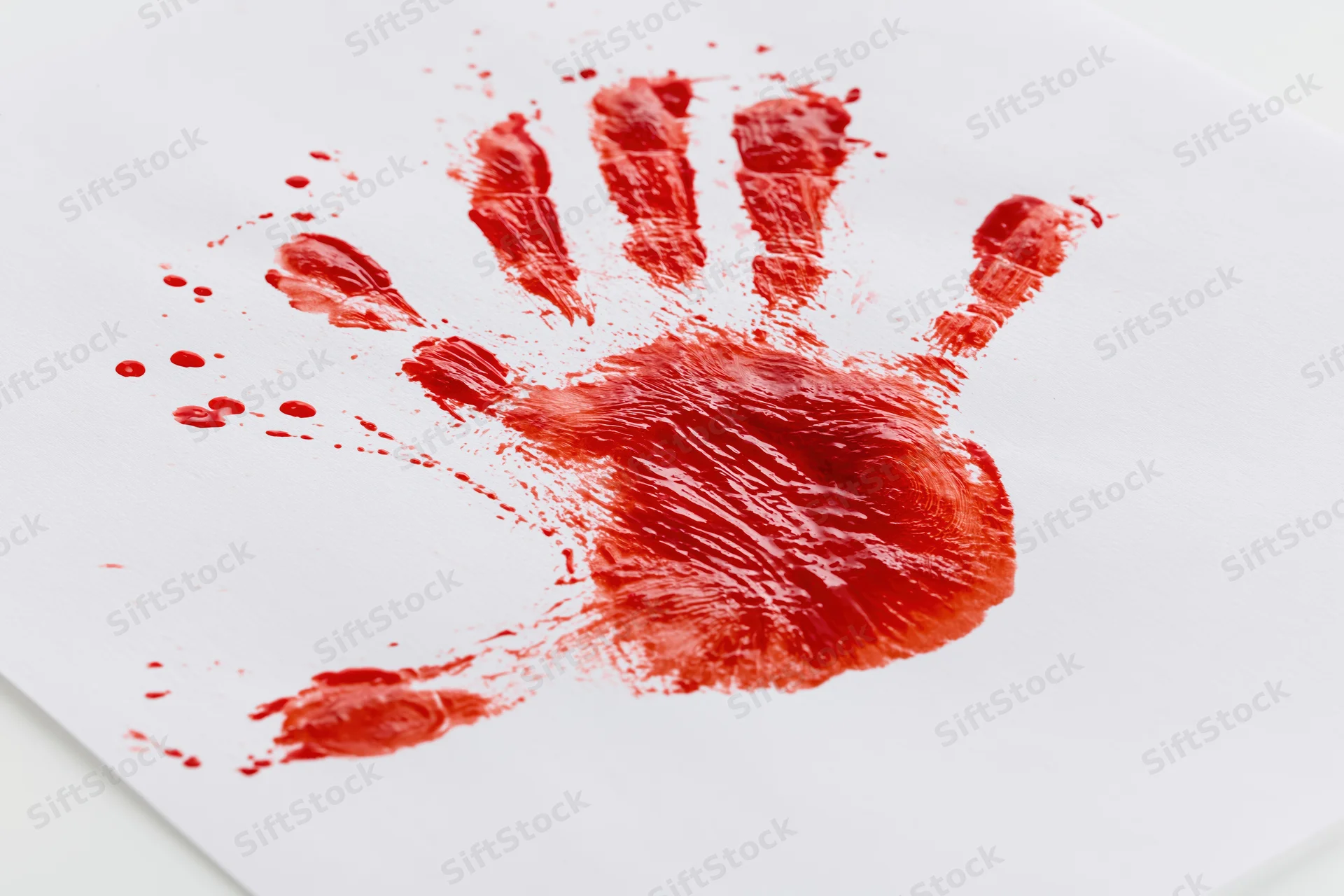 Red paint handprint pressed onto plain white paper