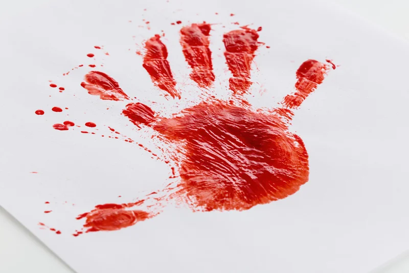 Red paint handprint pressed onto plain white paper