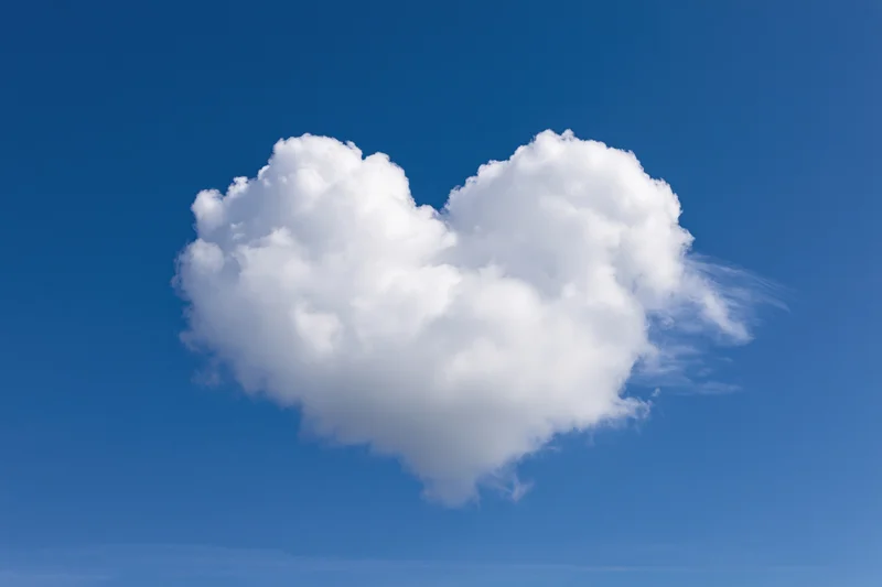 Heart-shaped cloud floating in clear blue sky