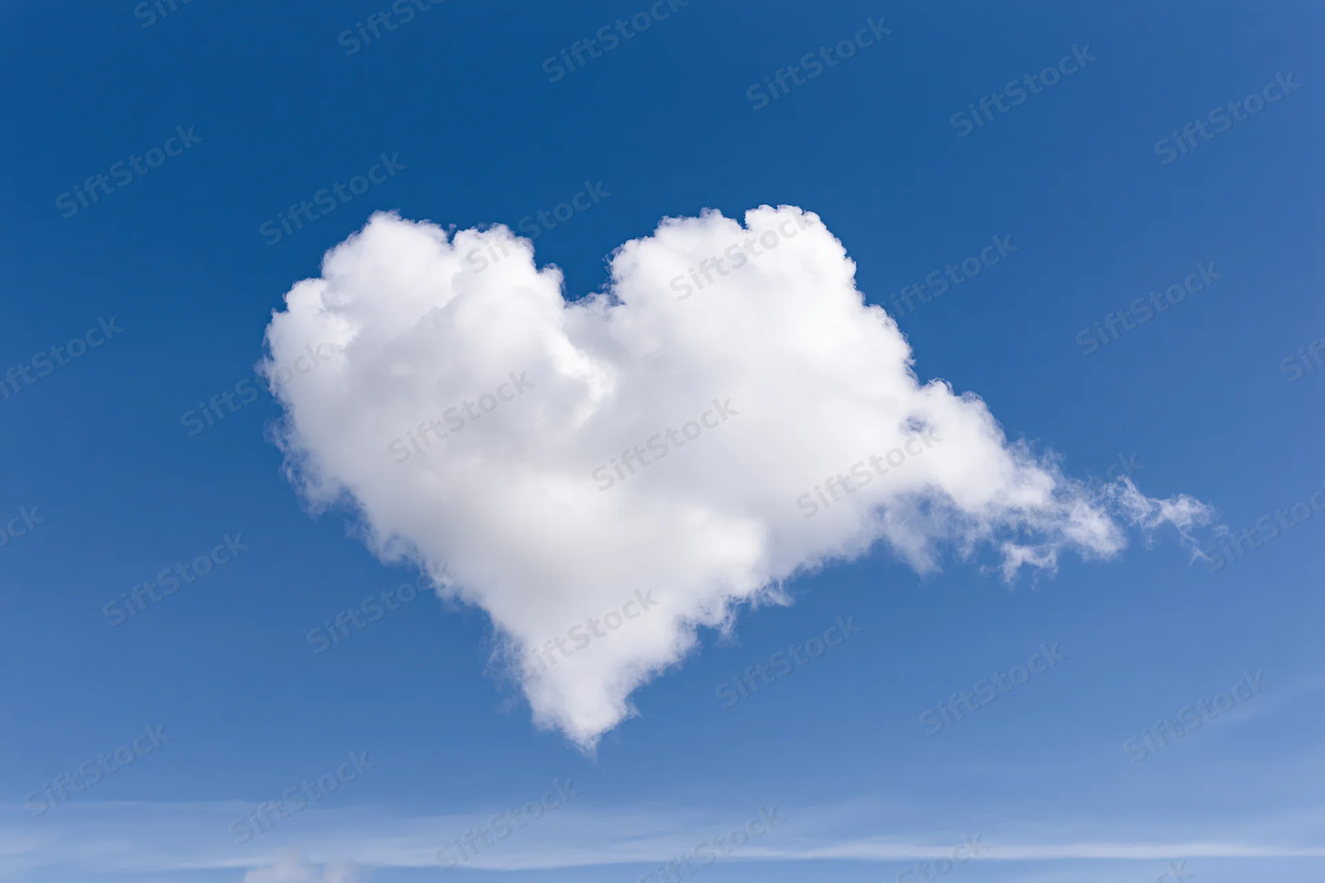 Heart-shaped cloud floating in clear blue sky