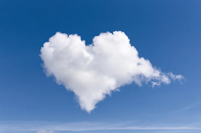 Heart-shaped cloud floating in clear blue sky