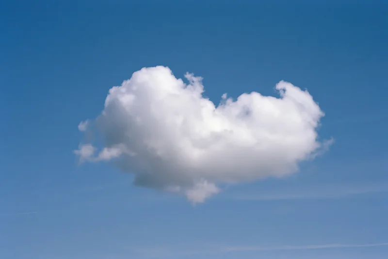 Heart-shaped cumulus cloud floating in clear blue sky