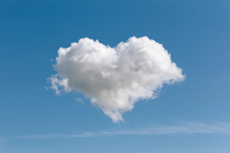 Heart-shaped cloud floating in clear blue sky