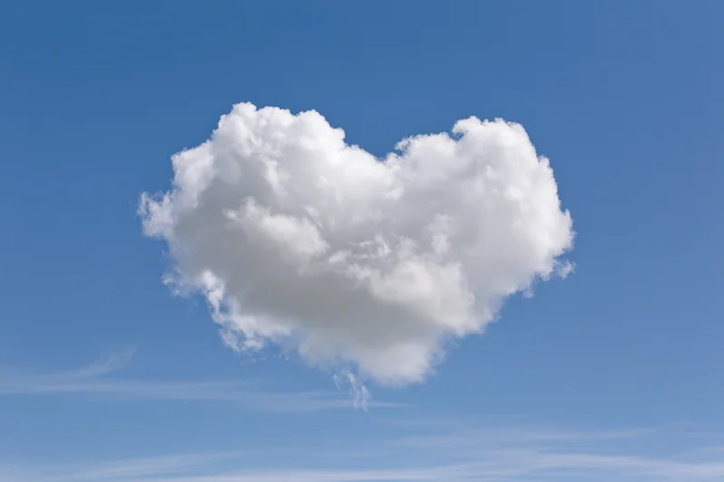 Heart-shaped cloud floating in clear blue sky