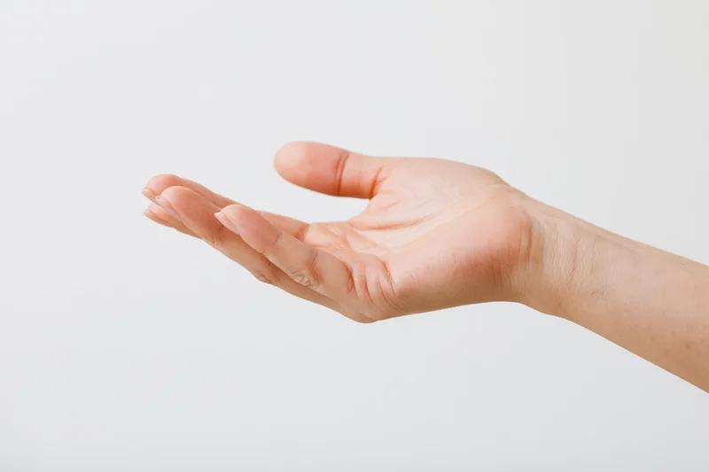 Woman's hand in open palm gesture against white background