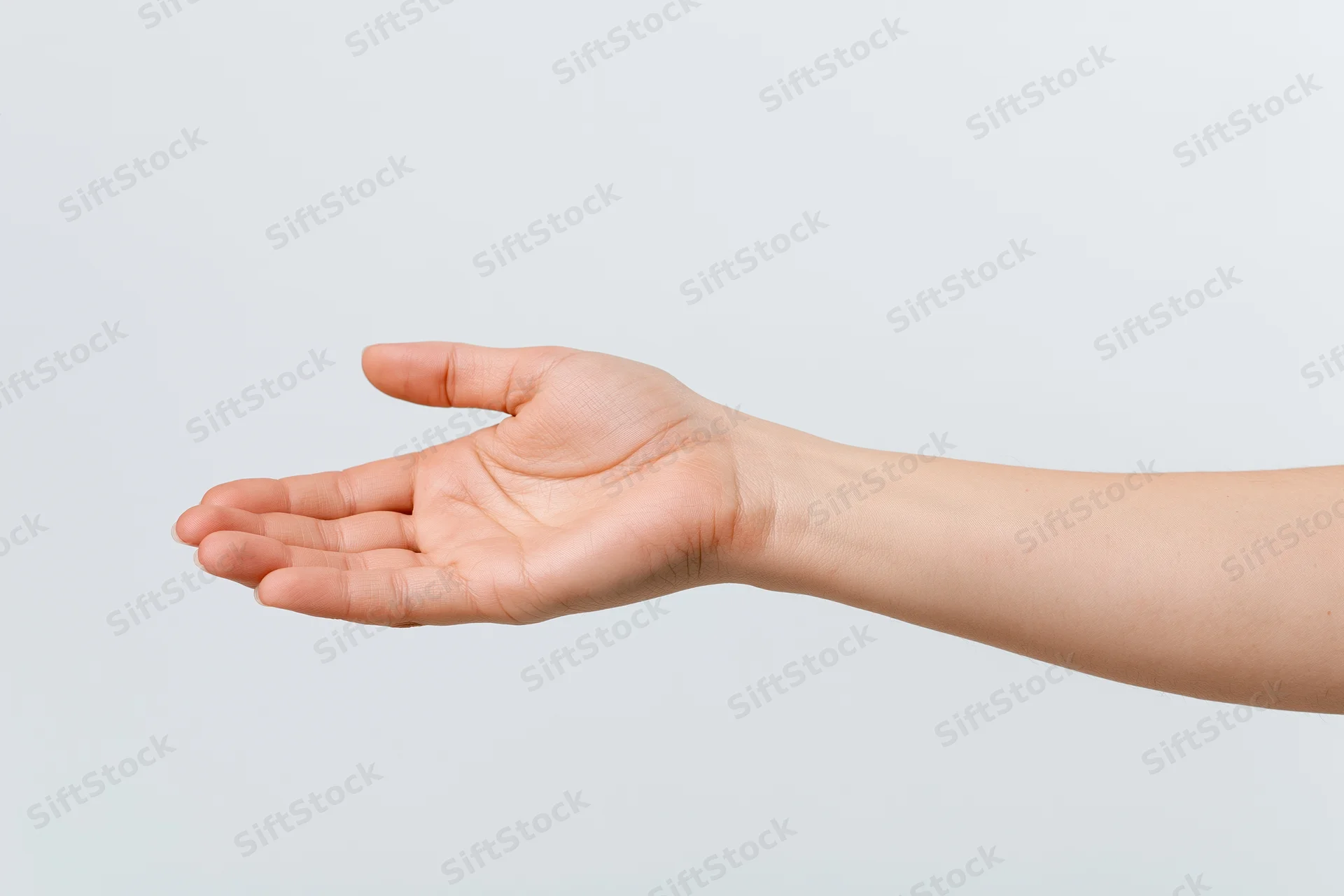 Woman's hand extended with open palm against plain background
