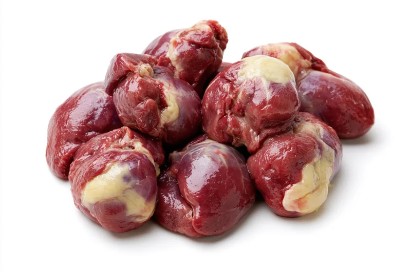 Raw chicken hearts piled together on white background