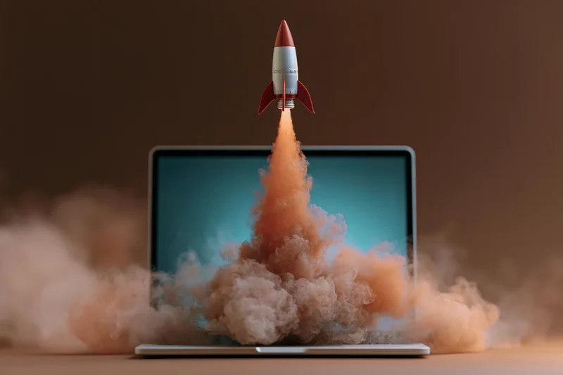 Small rocket launching from open laptop screen with smoke and fire
