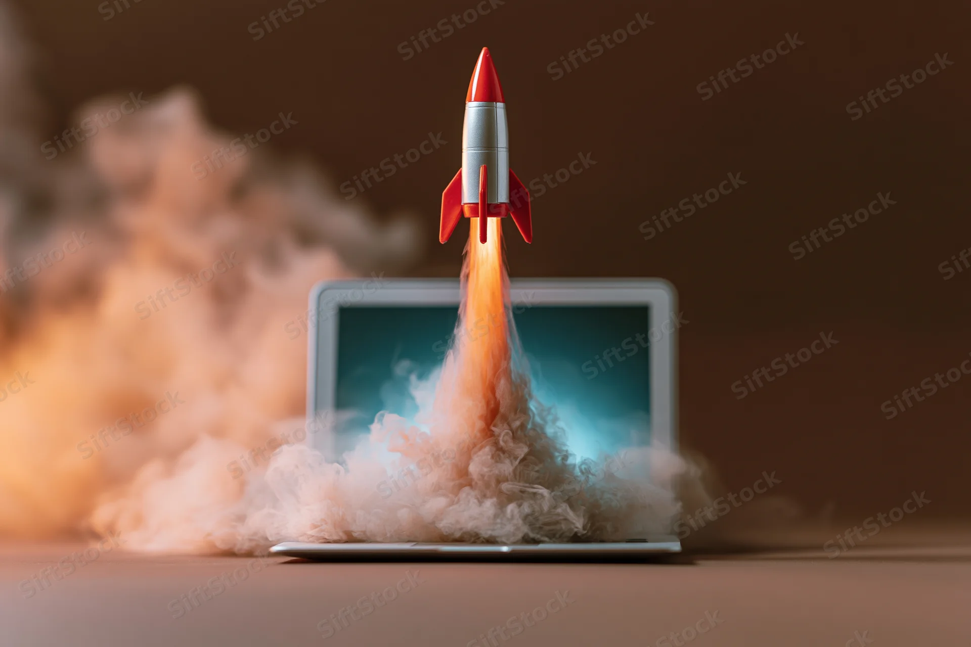 Small red and white rocket launching from open laptop screen with smoke and flame